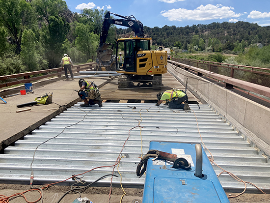 Crews install new steel decking on the County Road 108 (Thompson Creek Road) bridge near Carbondale.